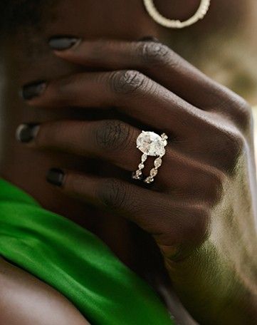 Model wearing diamond engagement ring and wedding ring bridal set.